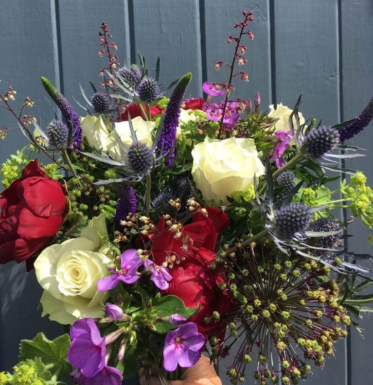 Bright seasonal bouquet with thistles and roses